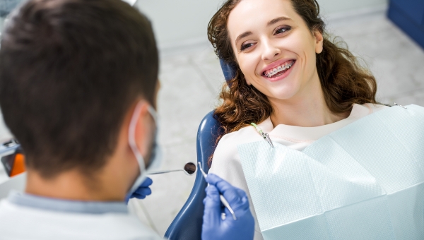 dentist checking patient's dental braces progress